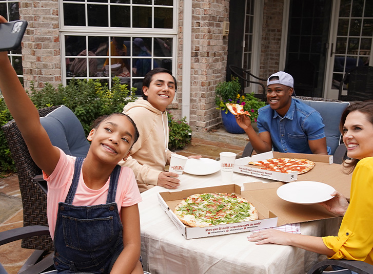 smiling friends eating pizza